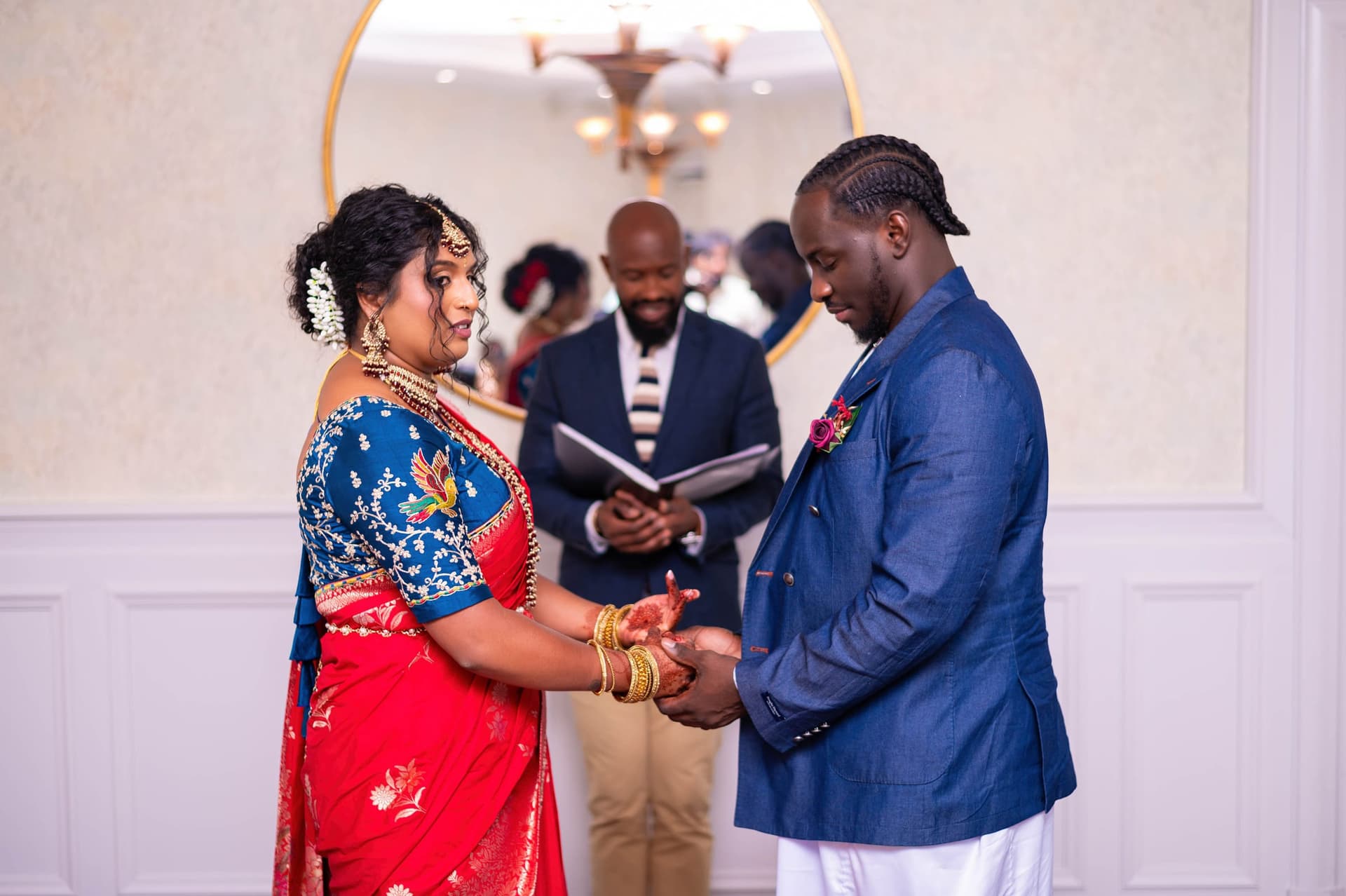 Hands held through the vows, the officiant reading from an open book behind them.