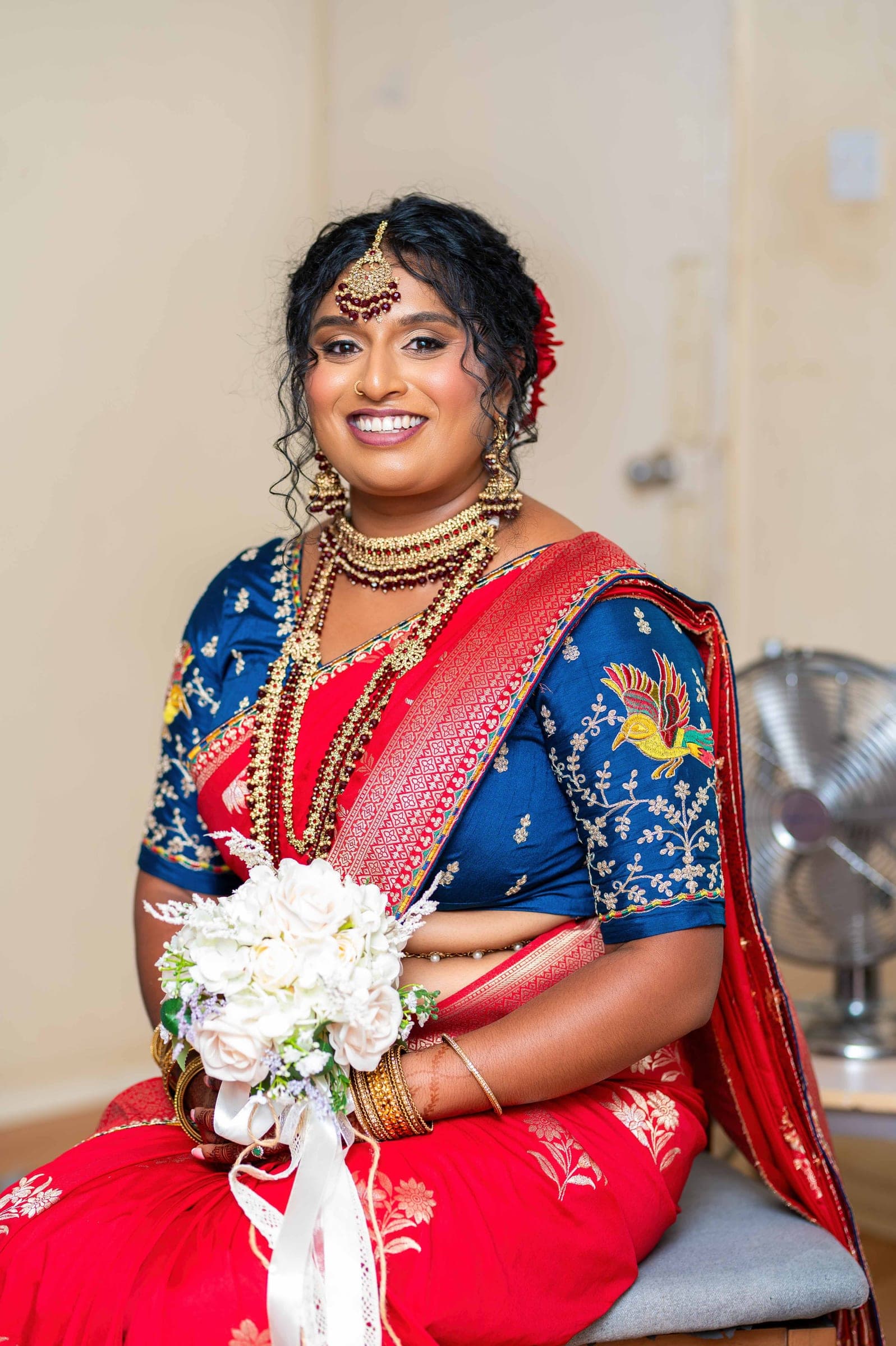 The same portrait a beat later, the bouquet lifted into her lap and her smile widening to the camera.