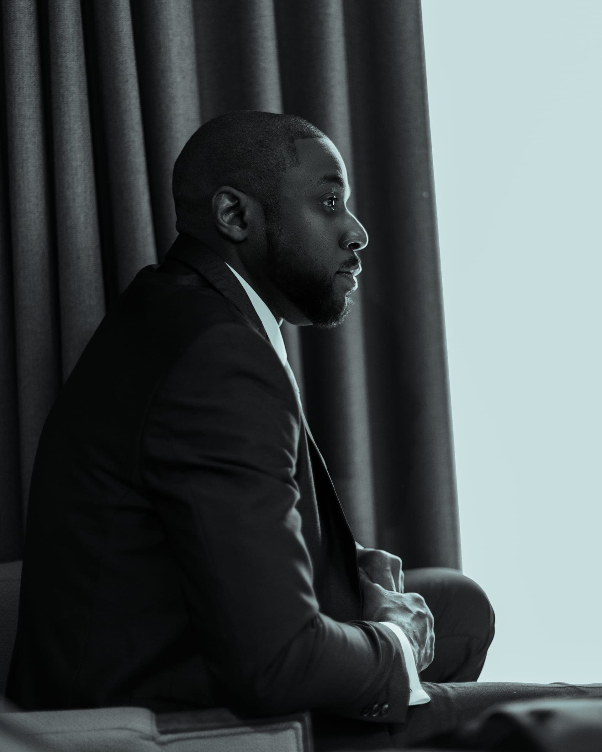The same quiet moment framed wider, his profile against the daylight.
