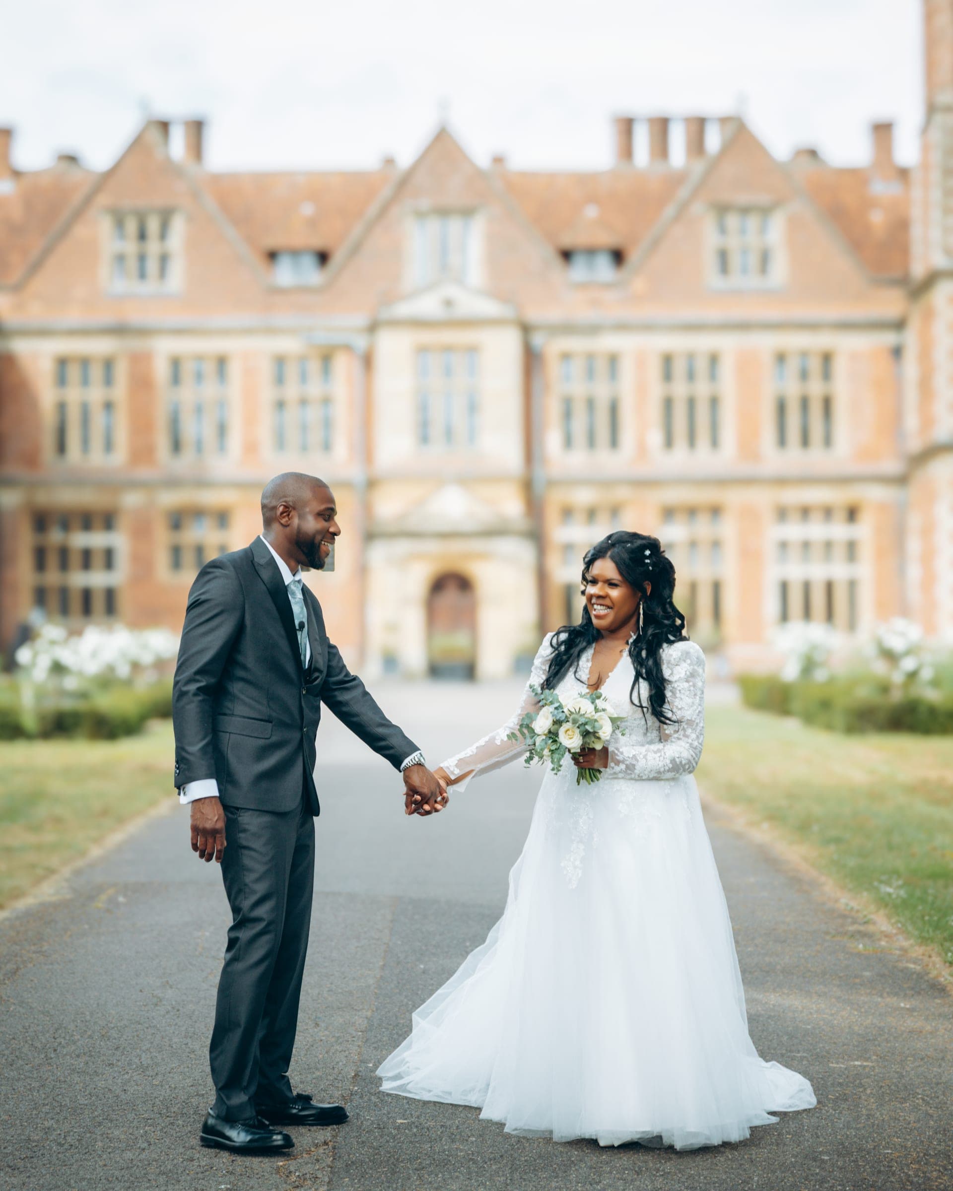 The two turn to face each other on the drive, hands joined, the house soft in the distance.
